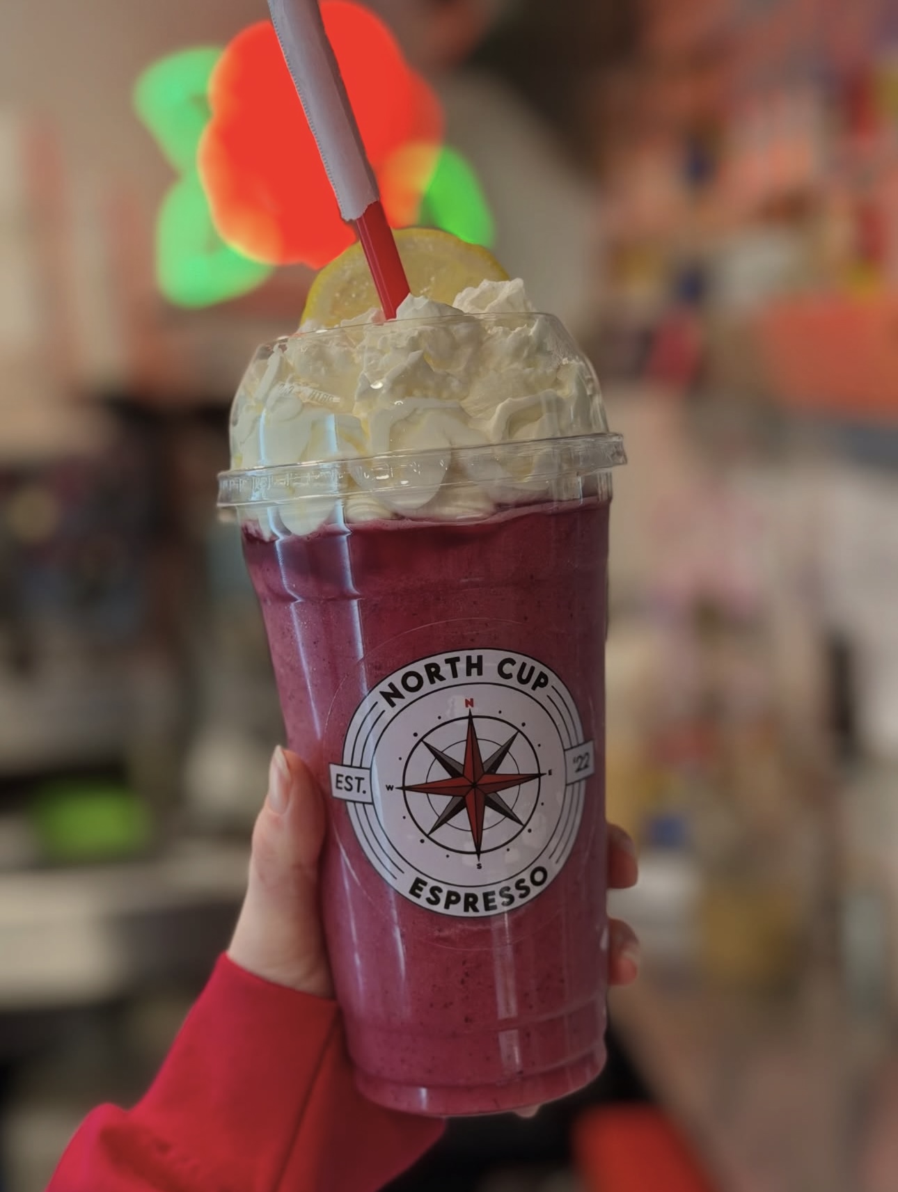 Berry blended drink with whipped cream and a lemon slice