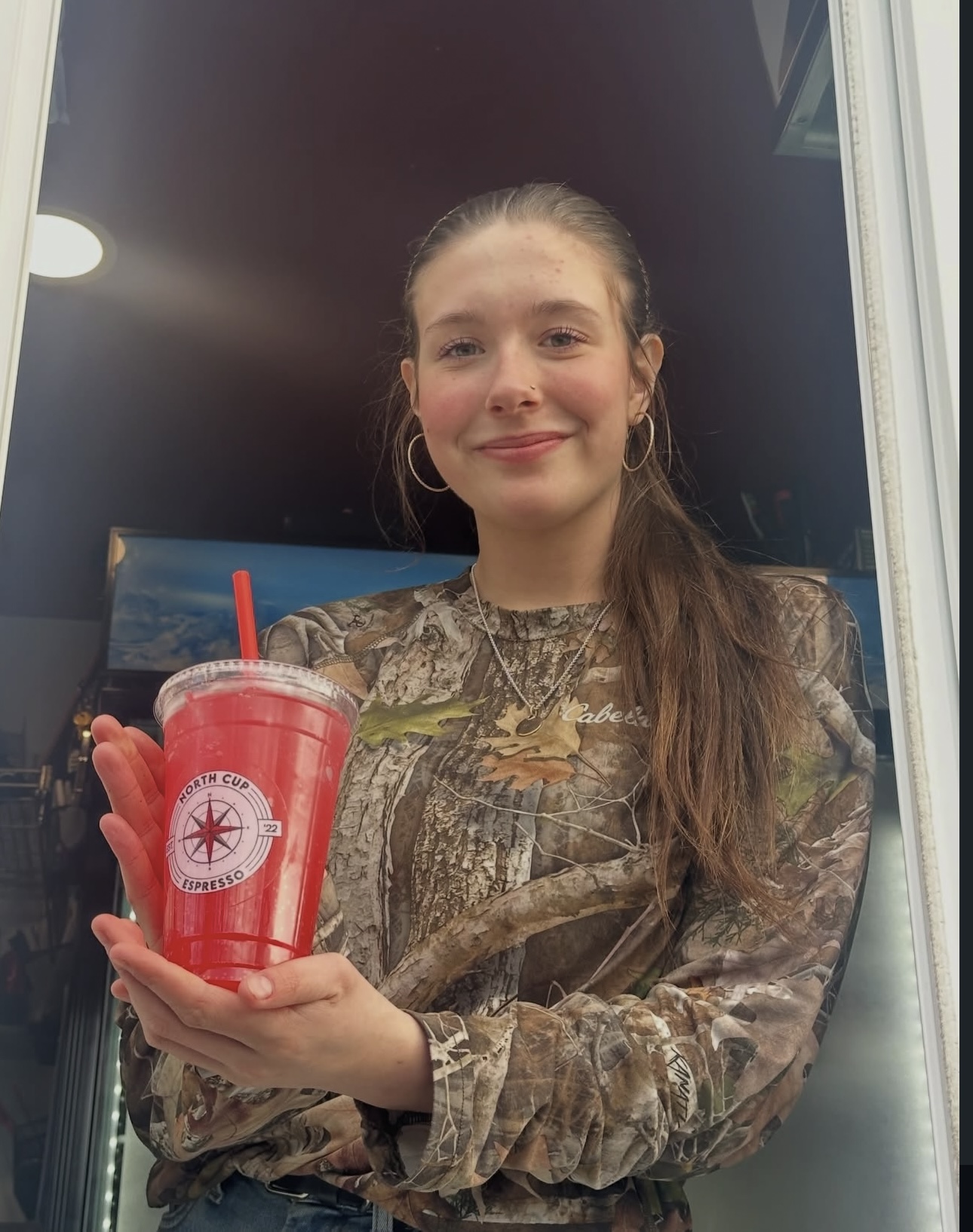 Guest holding a bright red North Cup Espresso refresher